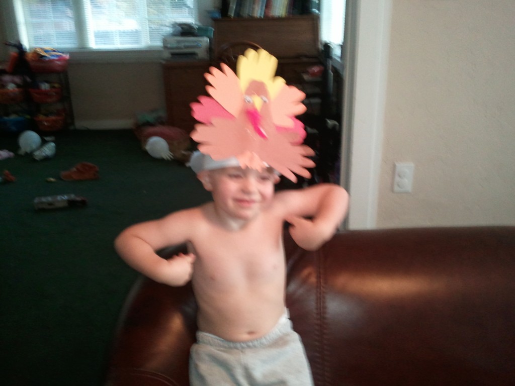 little boy with turkey crown and doing a turkey dance