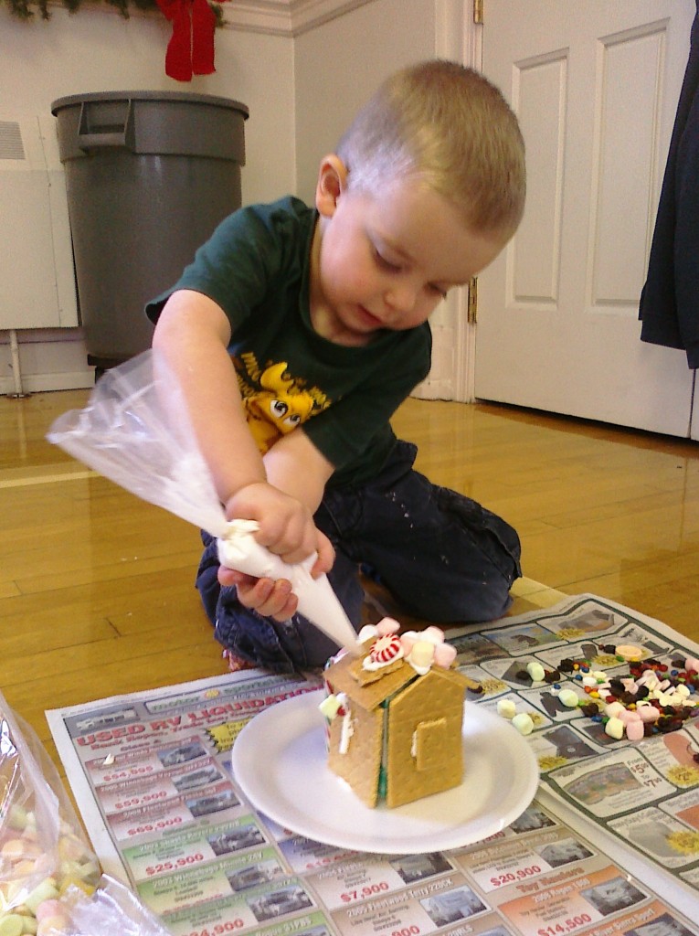 little boy making gingerbread house
